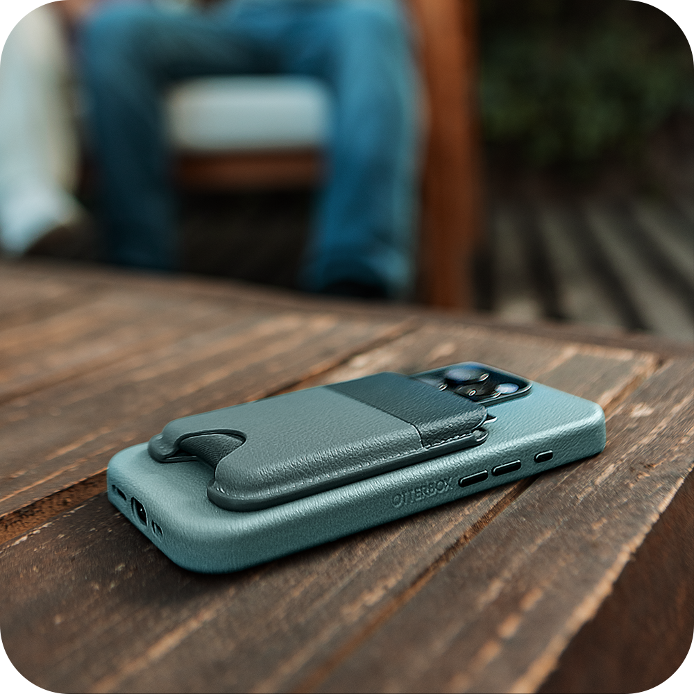 Teal cactus leather phone case with card holder on a wooden surface, blurred background